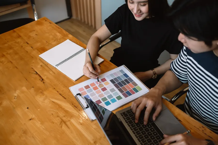 Équipe choisissant des couleurs autour d’une table en bois