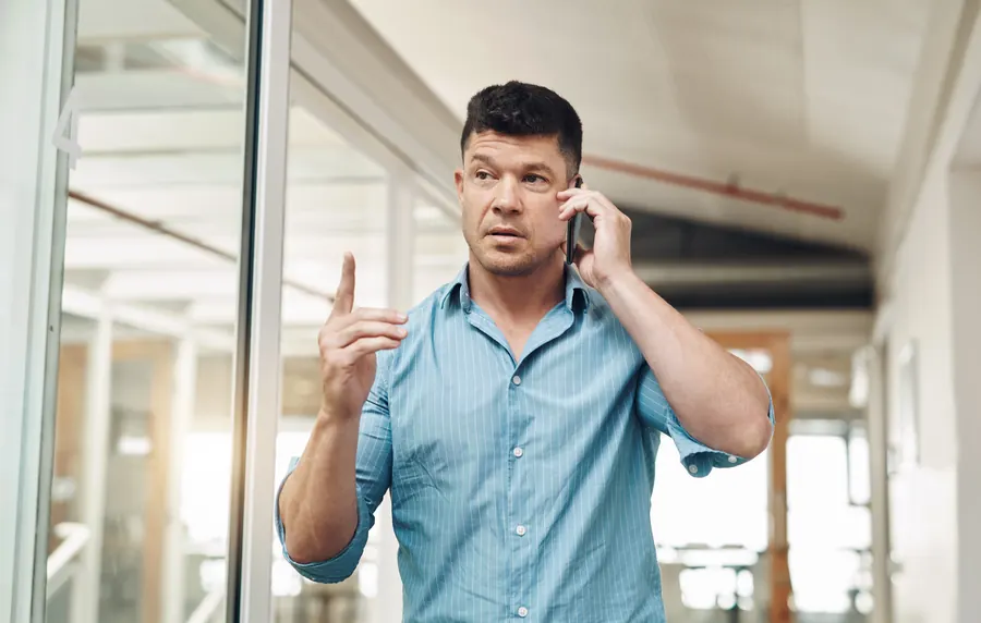Un gérant au téléphone, l'air sceptique, dans son bureau