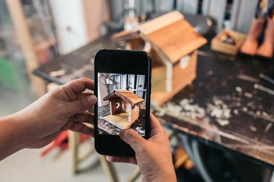 Un artisan photographie un nichoir qu’il vient de terminer : des photos récentes et réelles rendent la fiche plus convaincante.