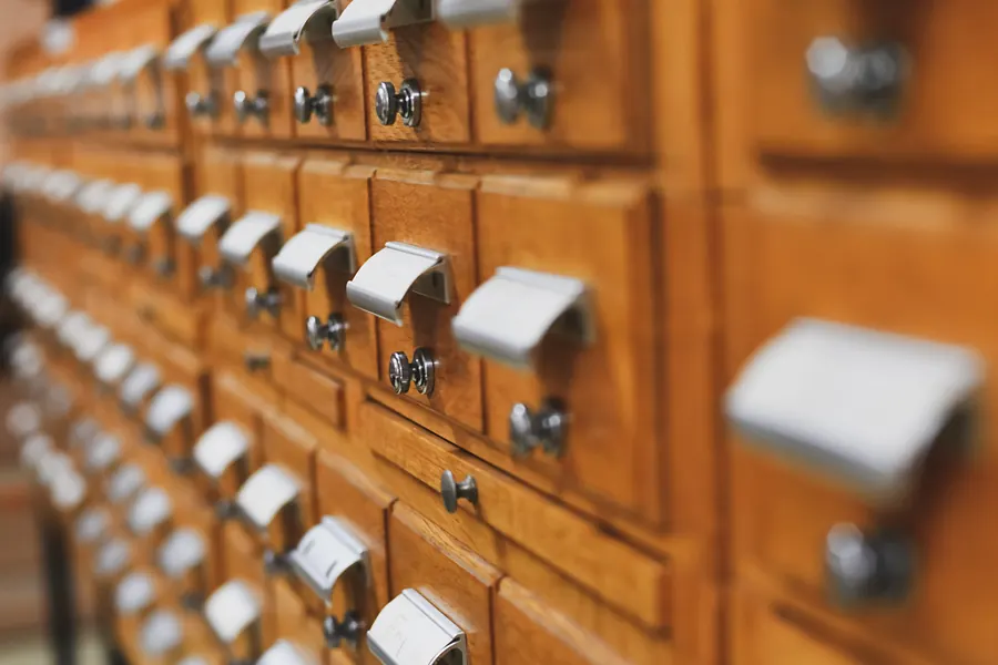 Les petits tiroirs en bois d'un ancien fichier de bibliothèque, vus en perspective