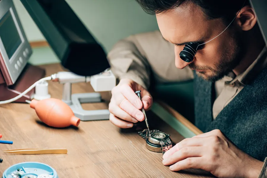 Horloger travaillant à la loupe sur une montre