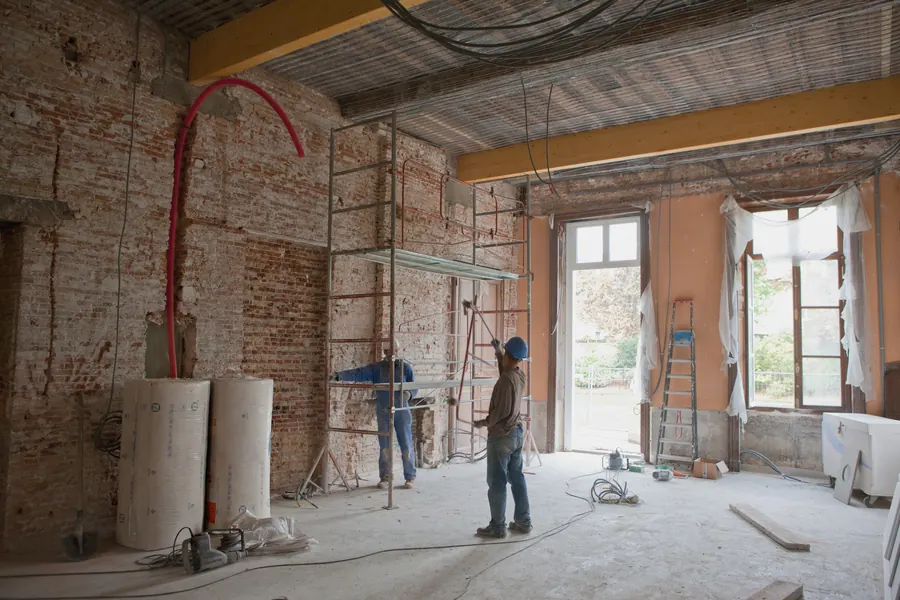 Ouvriers rénovant l’intérieur d’une maison ancienne