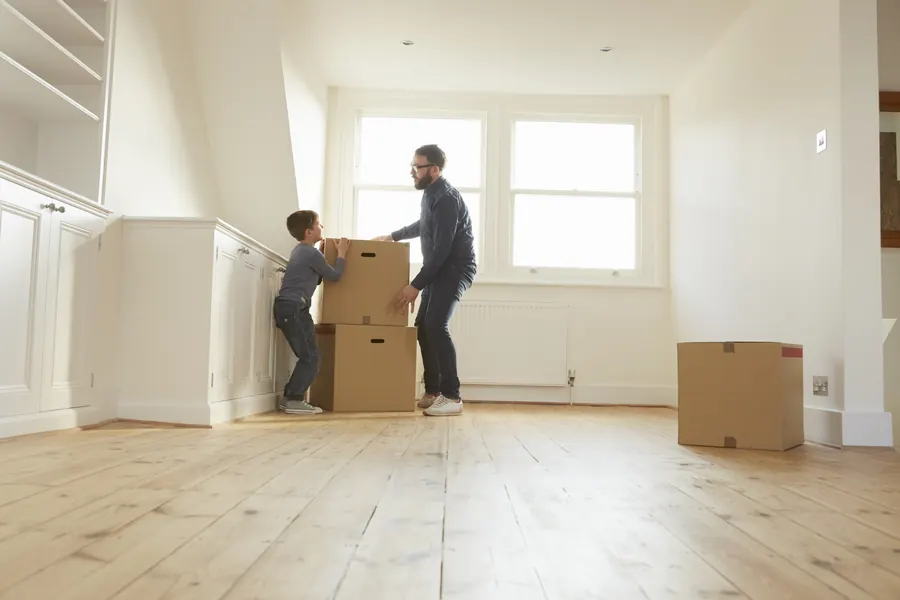Un père et son fils portent des cartons dans une maison neuve : on construit d’abord le nouveau site, puis on y transfère les contenus de l’ancien.