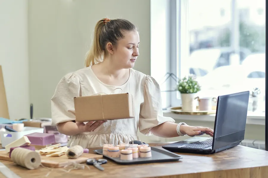 Une artisane prépare une commande : pour une boutique, un e-mail de commande qui n’arrive pas, c’est un client qui doute et un colis qui attend.