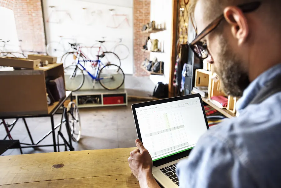 Un gérant de magasin de cycles parcourt ses chiffres sur son ordinateur : la Search Console lui dit sur quelles recherches son site apparaît.