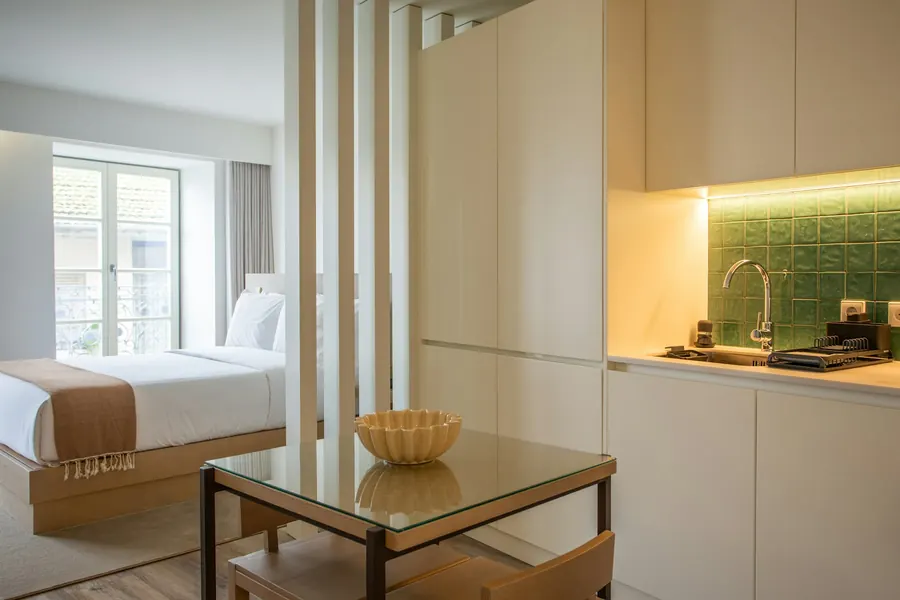 Chambre avec lit, table basse et coin cuisine ouverte