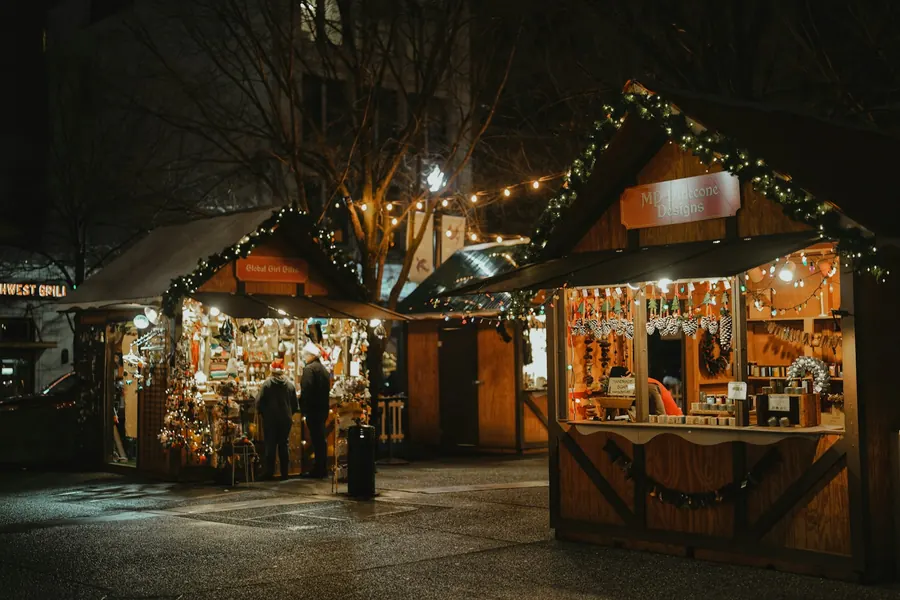 Marché de Noël dans une ville alsacienne à colombages, le soir, promeneurs emmitouflés