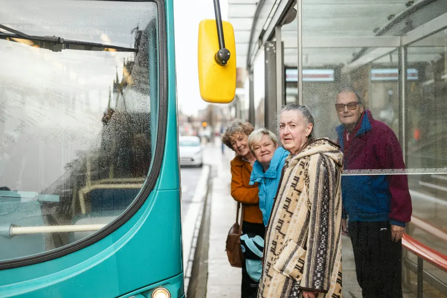 Groupe de retraités qui monte dans un bus en ville