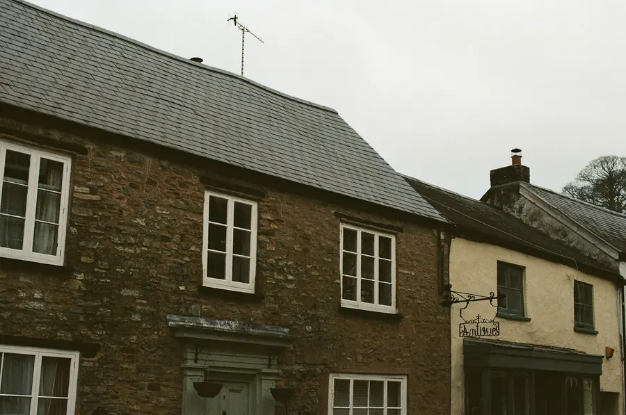 Maison de ville en pierre, toit d'ardoise, volets clairs