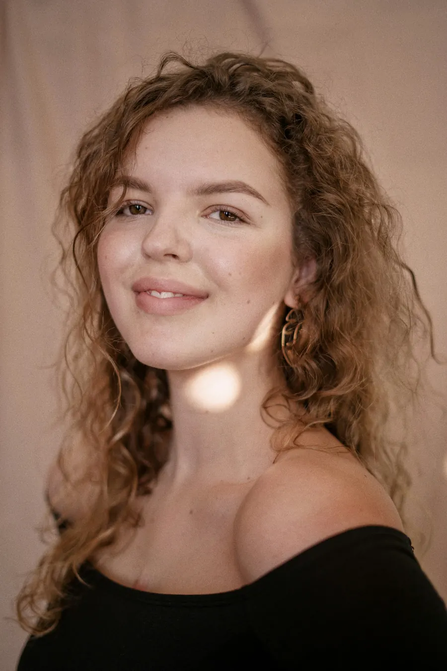 Portrait d'une femme aux cheveux roux bouclés et taches de rousseur