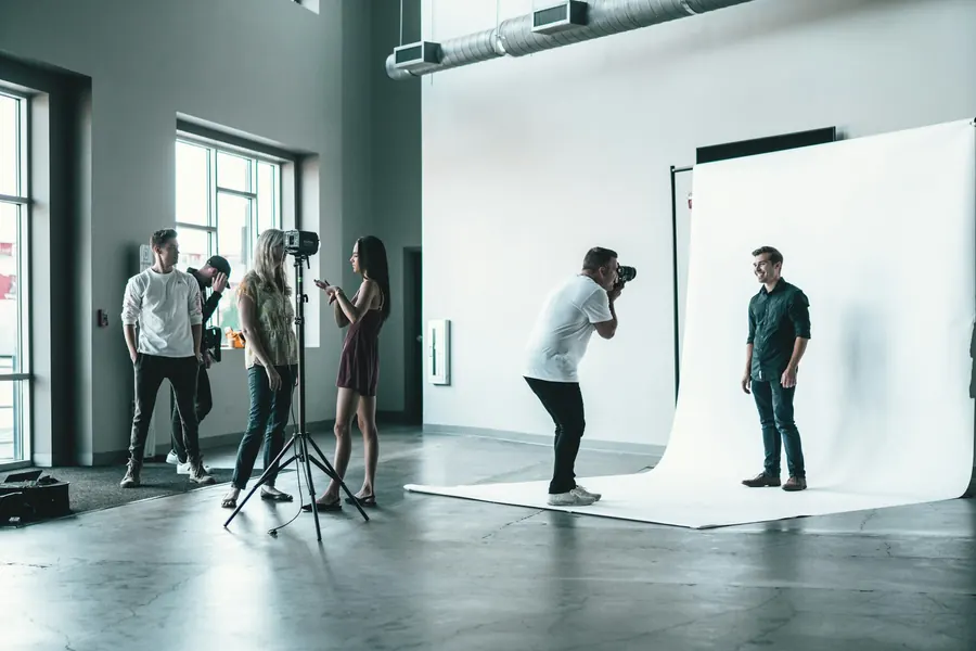 Séance de casting : photographe, mannequin et bookeuse dans un studio lumineux