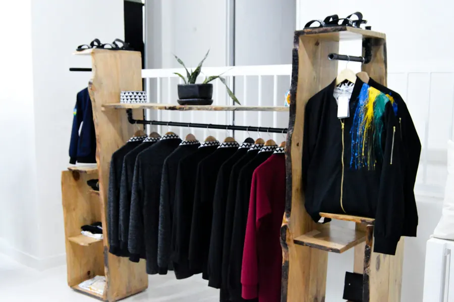 Boutique de vêtements, portants et tablettes en bois, vitrine
