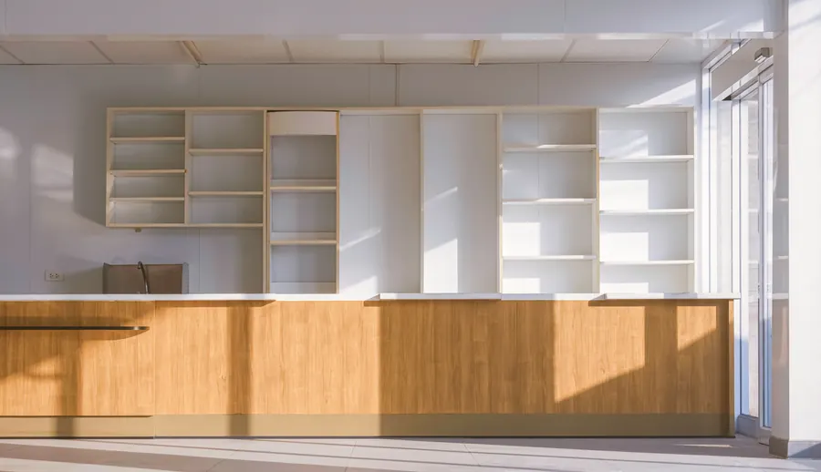 Boutique vide juste avant l'ouverture, mobilier en bois clair, lumière du jour