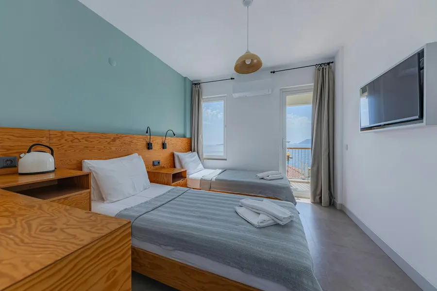 Chambre d'hôtel, tête de lit et bureau en bois, fenêtre sur la mer