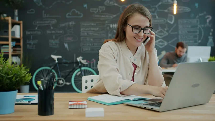 Responsable de secteur au téléphone devant un planning mural, petite agence