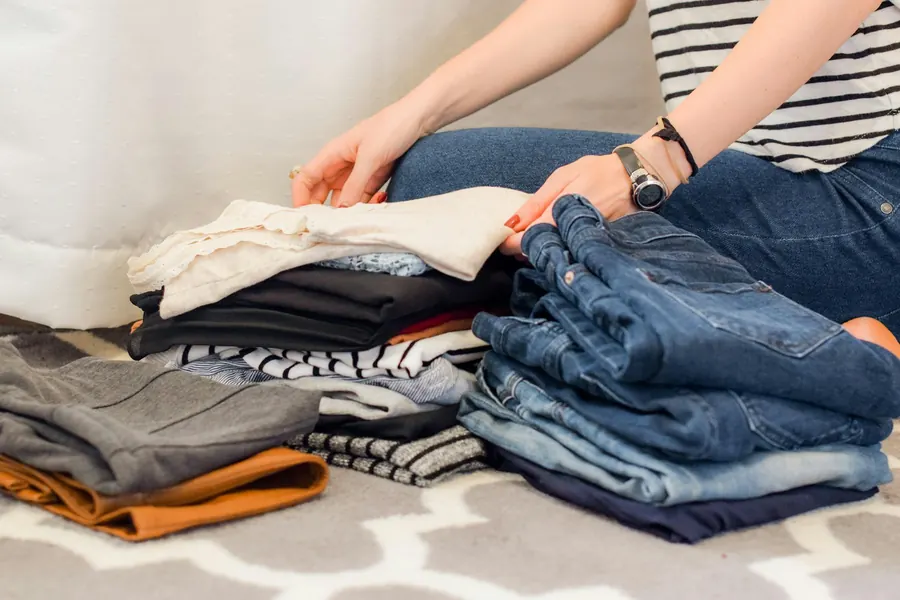 Mains qui plient des vêtements de couleurs variées