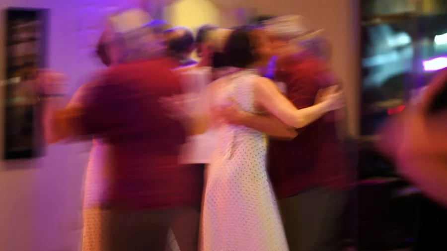 Piste pleine en fin de soirée, invités de tous âges, flou de mouvement