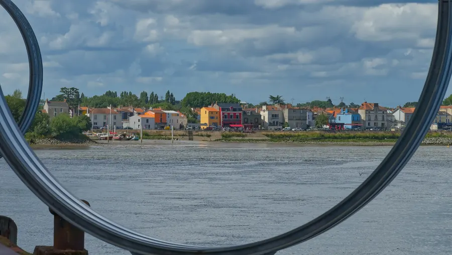 Maisons colorées au bord de la Loire vues à travers un anneau métallique