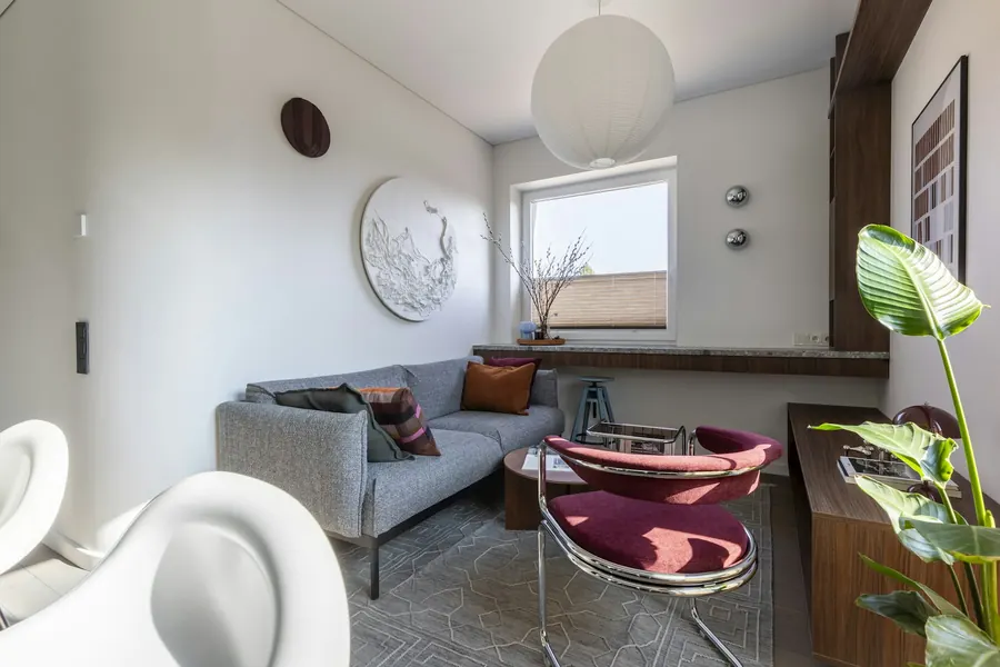 Salon moderne avec canapé gris et fauteuils colorés
