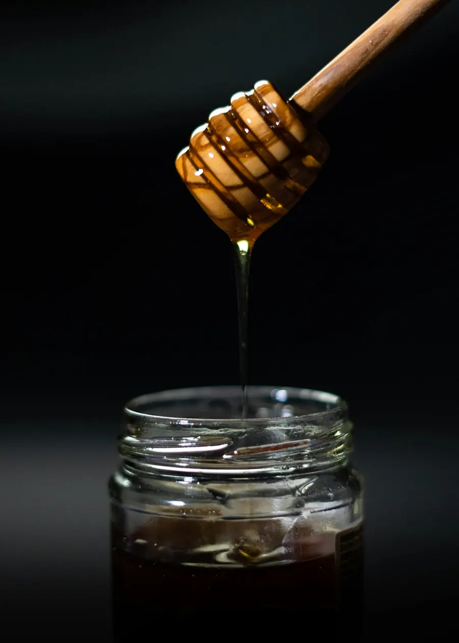 Pot de miel ambré foncé à contre-jour