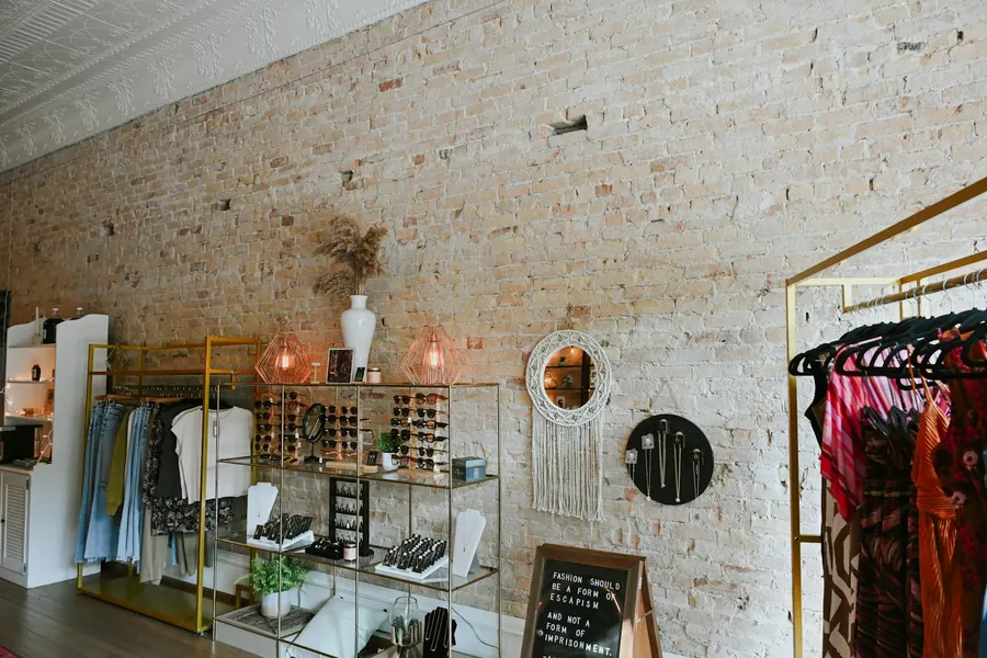 Boutique de prêt-à-porter, pierre apparente, mobilier en bois clair