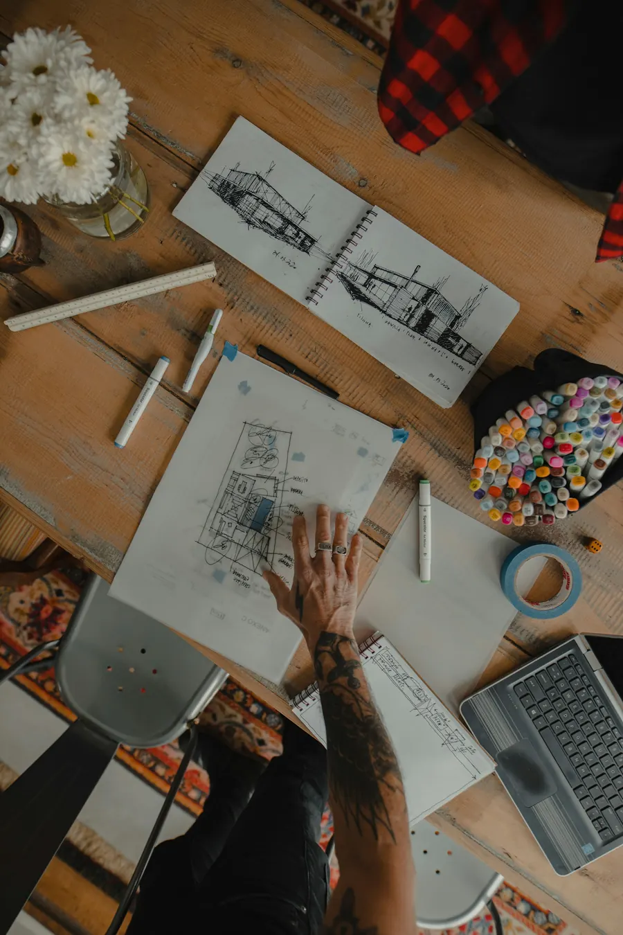 Plan dessiné à la main, crayons et nuancier sur le bureau