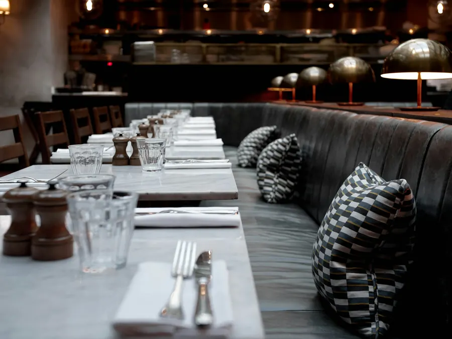 Banquette sur mesure et table dressée dans un restaurant chaleureux, sans vue sur le port