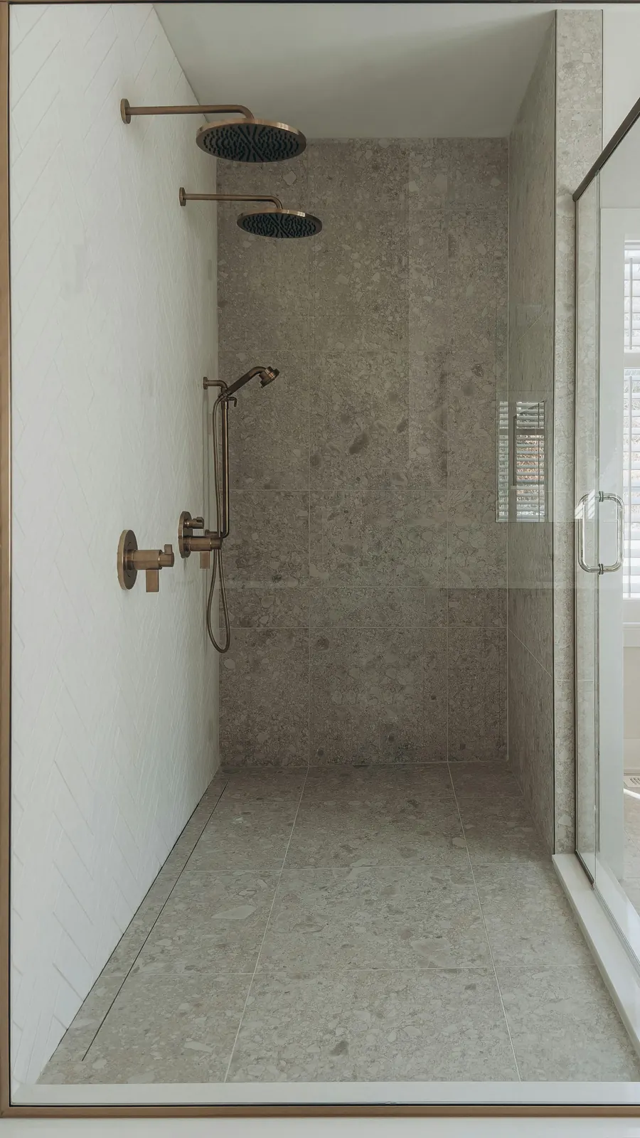 Douche à l'italienne avec robinetterie laiton, mur en pierre grise, plafond droit