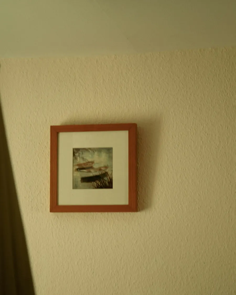Petit cadre marron accroché au mur, image floue peu distincte, pas de pont visible
