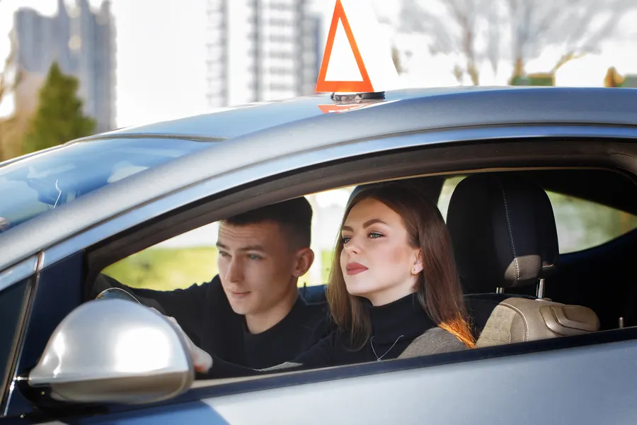 Voiture d'auto-école sur un rond-point de campagne, lumière de fin de journée
