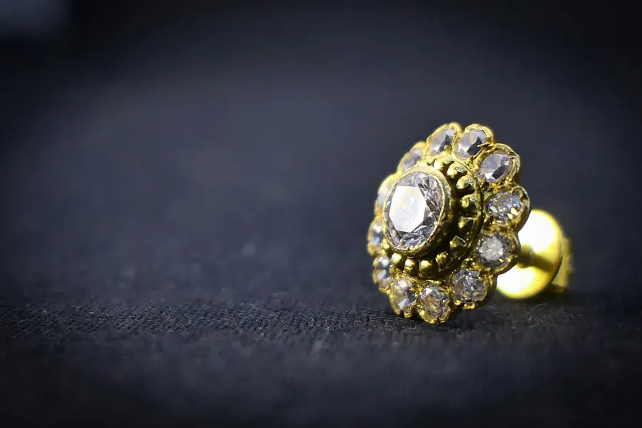 Bague ancienne en or avec pierres facettées, fond en tissu bleu marine foncé