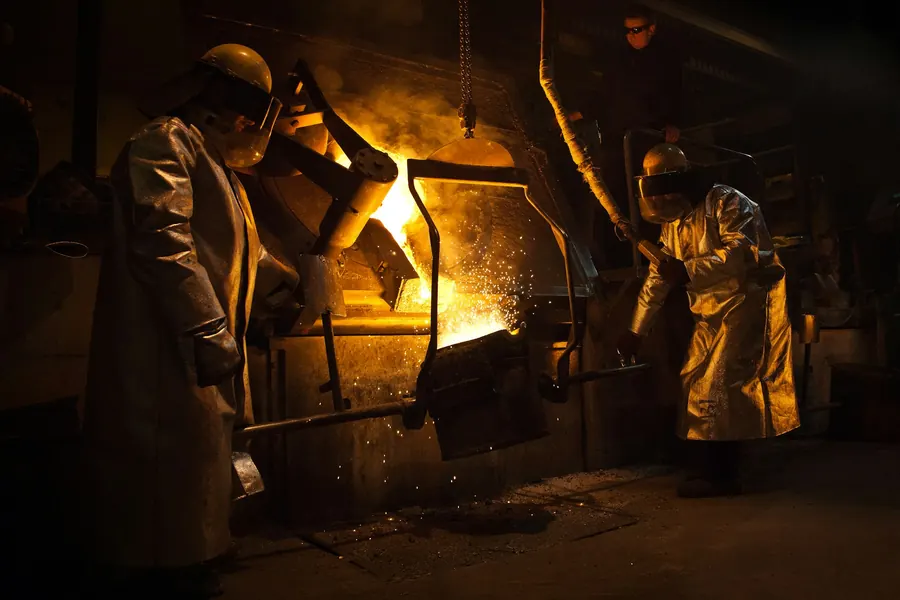 Atelier de fonderie, four ouvert et ouvriers équipés, étincelles