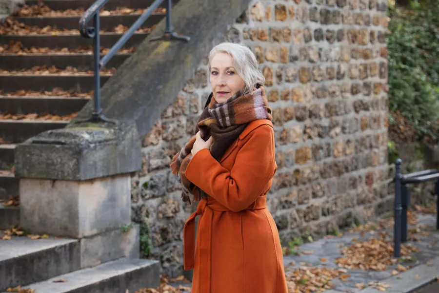 Cliente en manteau de laine sur des remparts, lumière d'automne