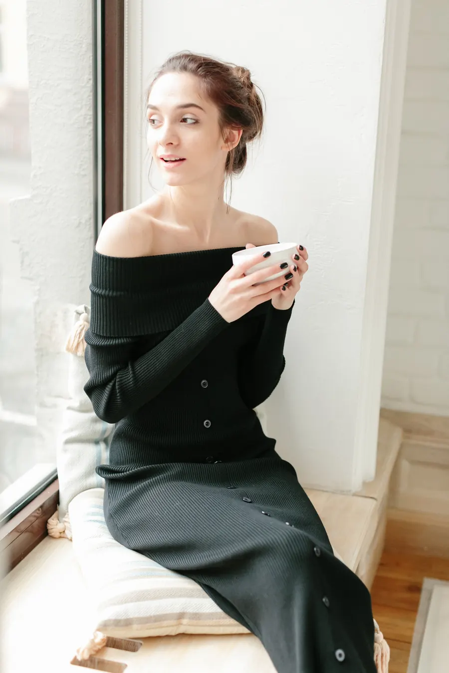 Robe en maille noire, longueur midi, lumière de fenêtre