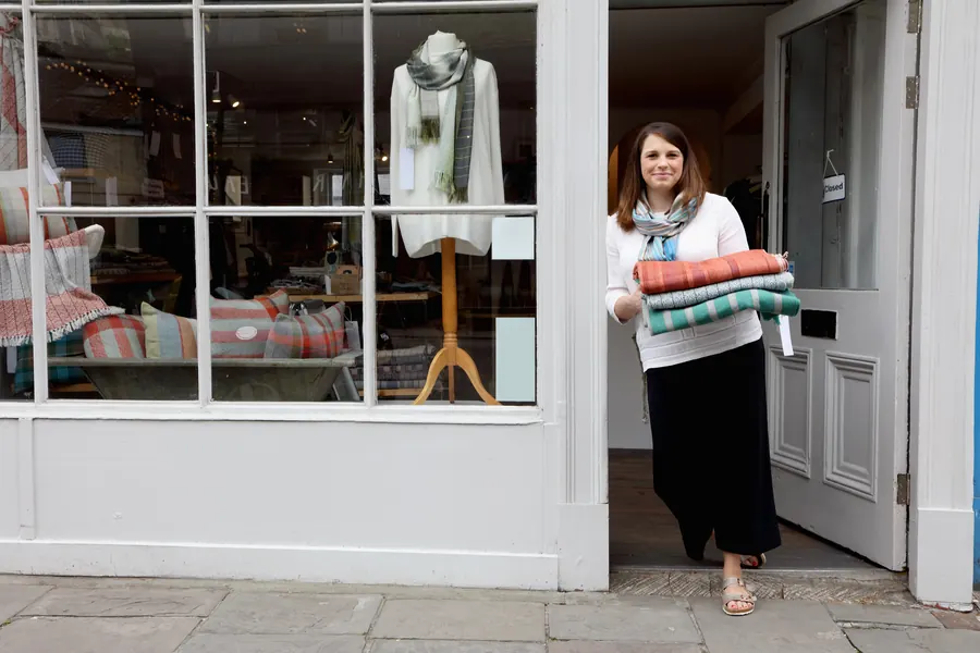 Vitrine de boutique dans une rue à colombages, pulls en présentation