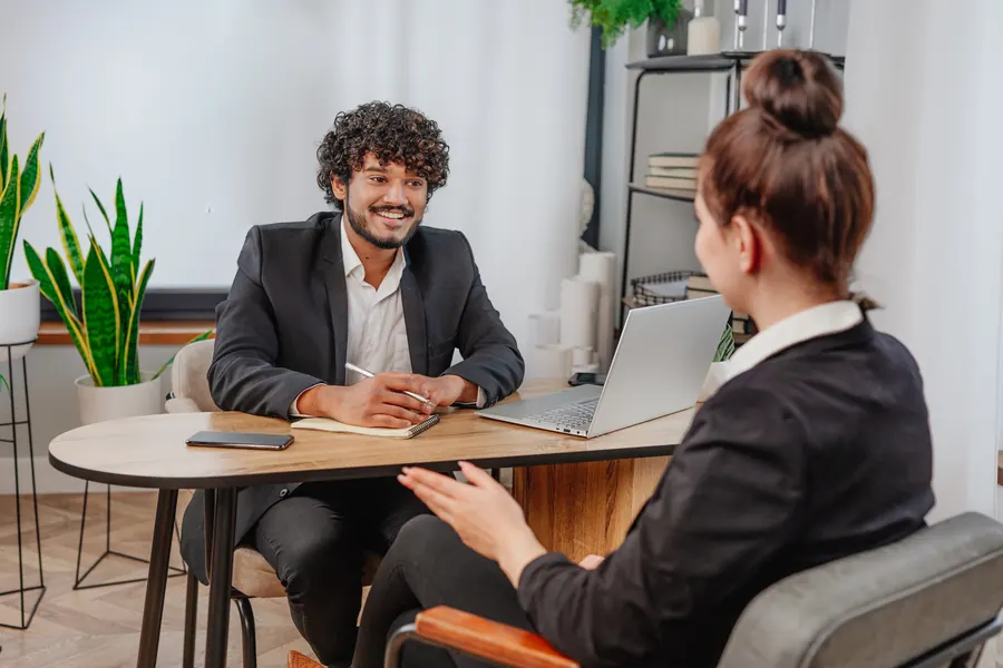 Entretien détendu entre une recruteuse et un candidat, bureau lumineux