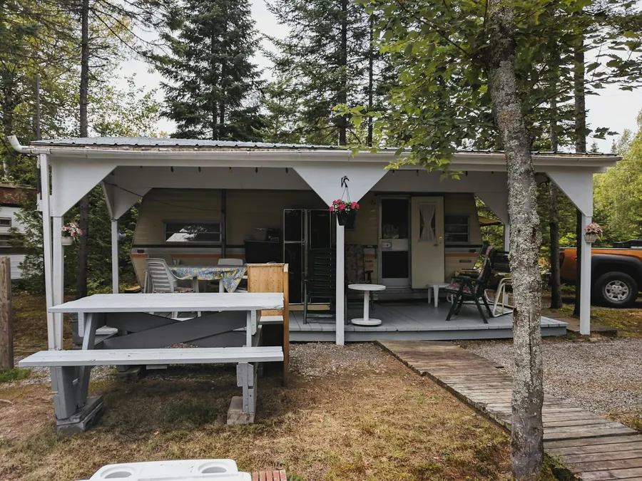 Mobil-home avec véranda couverte et table de pique-nique dressée
