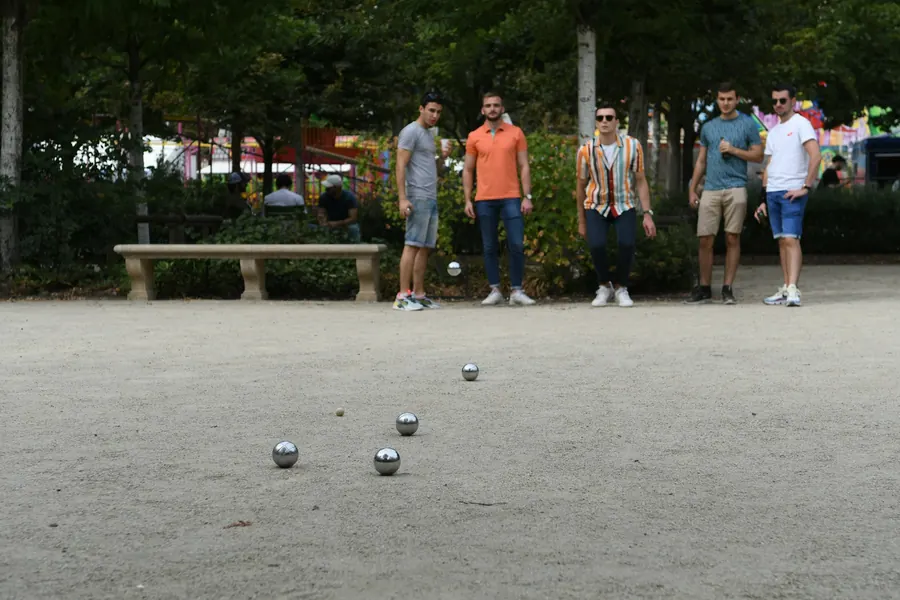 Partie de pétanque en journée sous les arbres