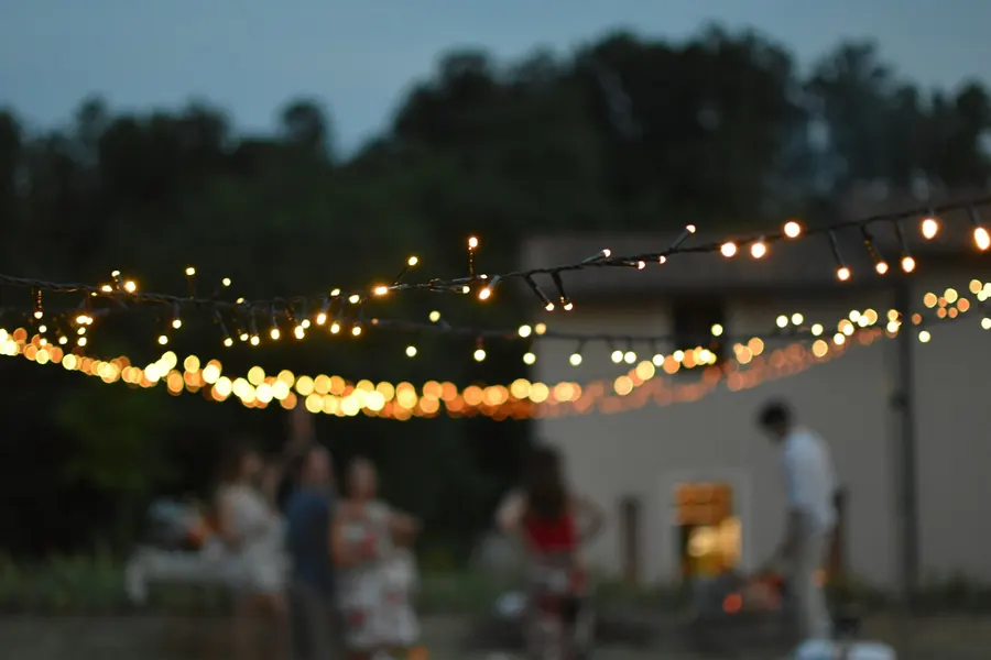 Soirée en plein air sous des guirlandes lumineuses avec un groupe