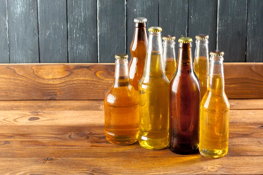 Bouteilles de cidre fermier sur une étagère en bois