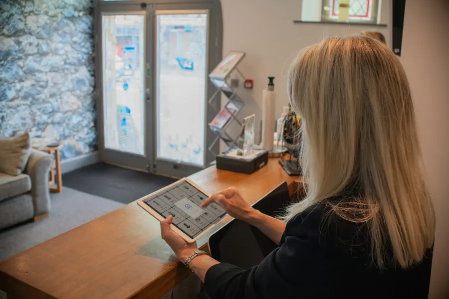 Femme à un comptoir d'accueil avec une tablette