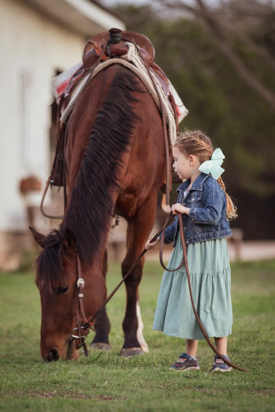 Petite fille tenant la longe à côté d'un grand cheval