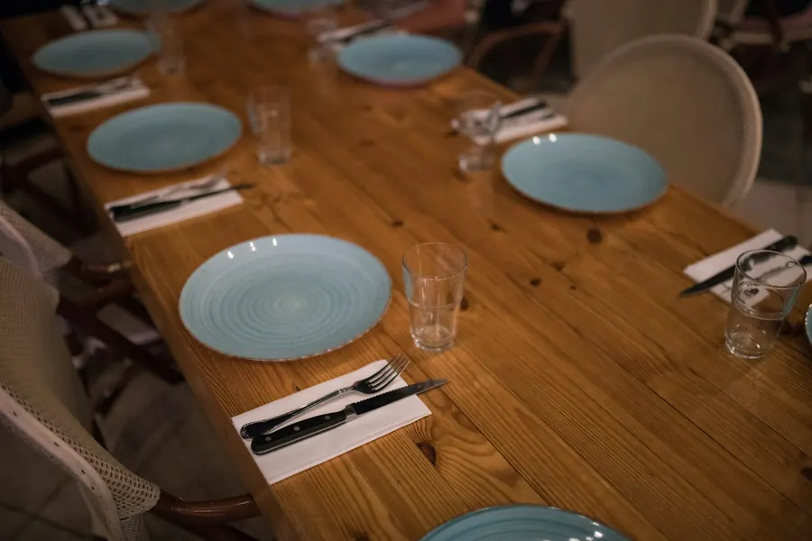 Table de restaurant dressée avec assiettes et bols en grès artisanal