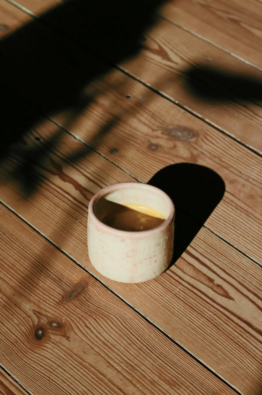 Tasse en grès émail blanc laiteux sur une table en bois