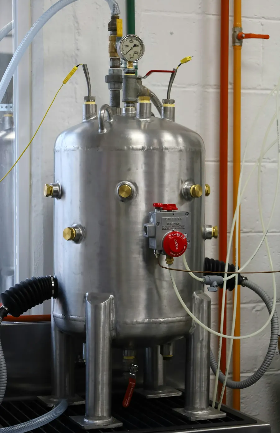 Cuve inox double enveloppe terminée, posée sur ses pieds dans l'atelier, reflets brossés