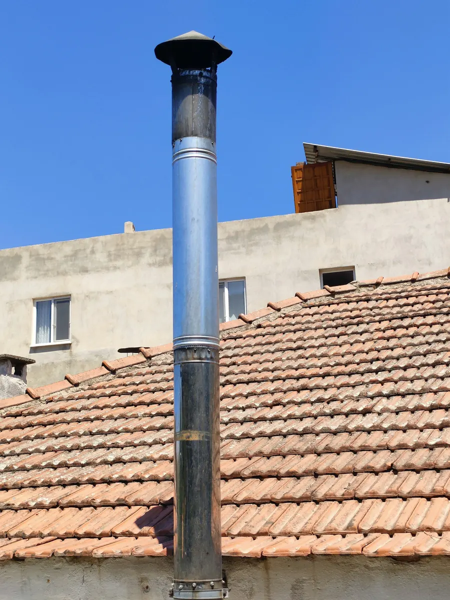 Conduit métallique installé sur un toit en tuiles