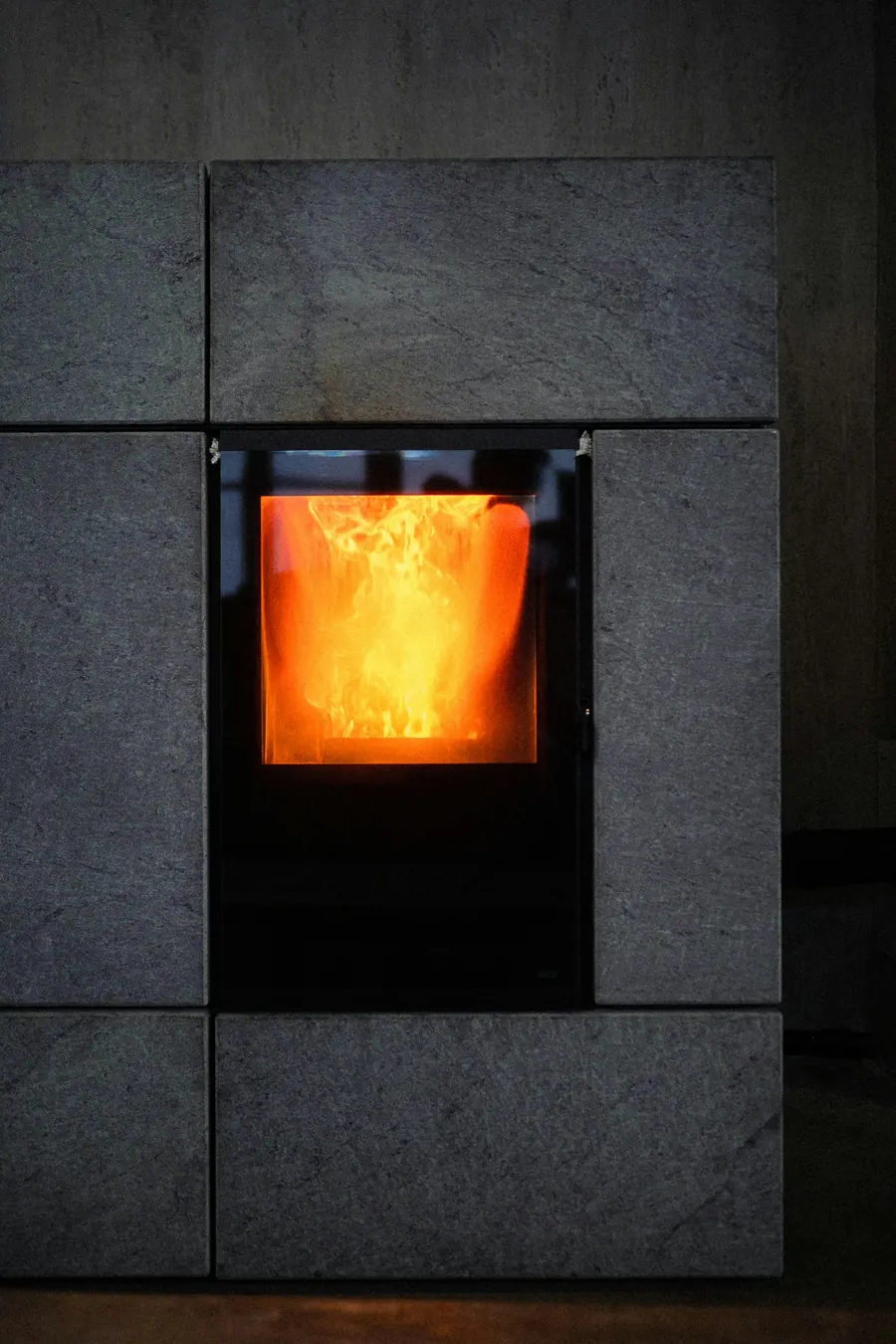 Poêle noir moderne avec flamme visible, intérieur contemporain