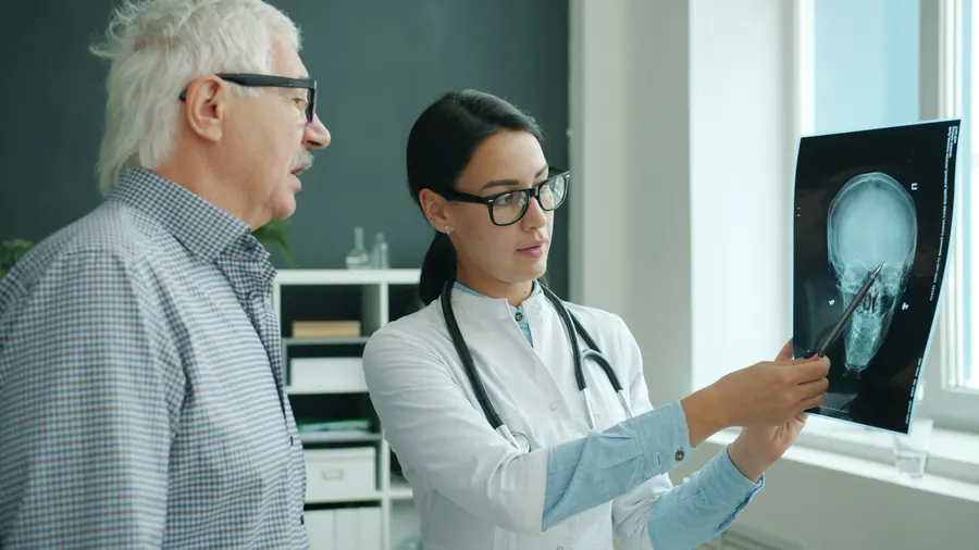 La praticienne lit un compte rendu d'imagerie avec le patient