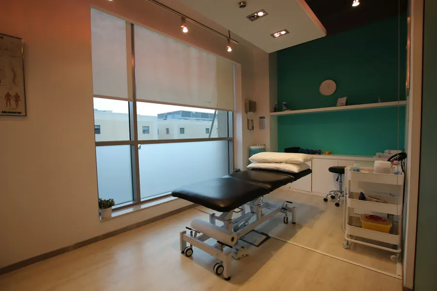 Table de soins vide dans une pièce calme, parquet, fenêtre