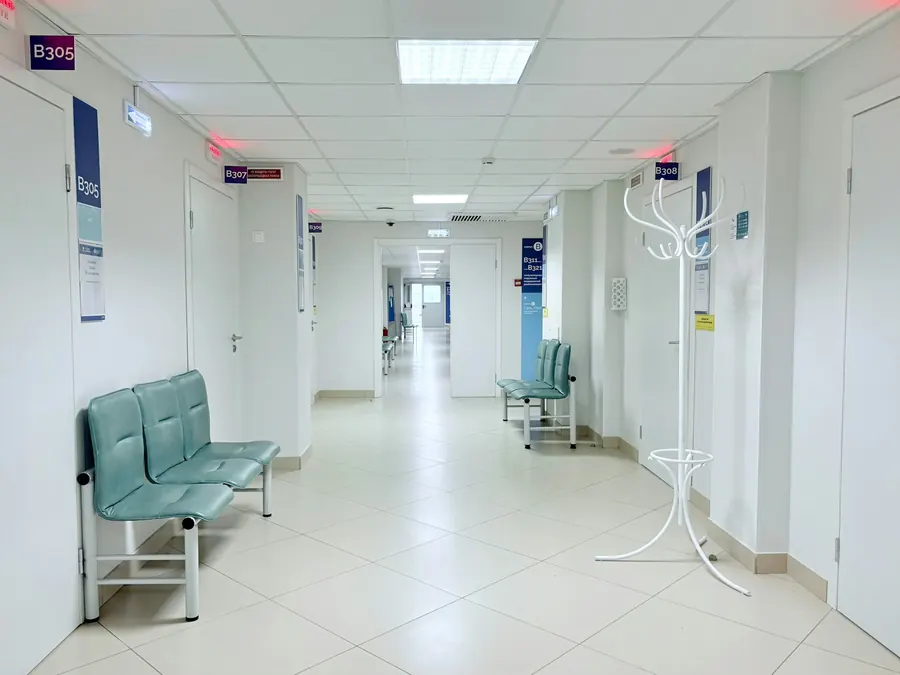 Couloir de clinique vide, lumière du jour, portes de chambres